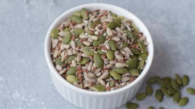 Sağlıklı yiyecekler için kabuklu ayçiçeği, susam, balkabağı ve keten tohumu çekirdekleri. Tasarımınız için gıda arka planı olarak tohumlar ve tahıllar.