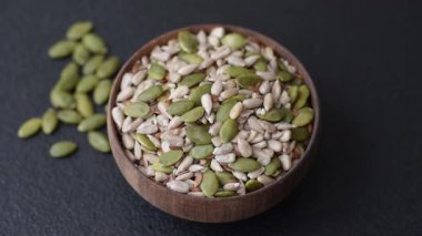 Sağlıklı yiyecekler için kabuklu ayçiçeği, susam, balkabağı ve keten tohumu çekirdekleri. Tasarımınız için gıda arka planı olarak tohumlar ve tahıllar.