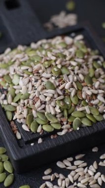 Sağlıklı yiyecekler için kabuklu ayçiçeği, susam, balkabağı ve keten tohumu çekirdekleri. Tasarımınız için gıda arka planı olarak tohumlar ve tahıllar.