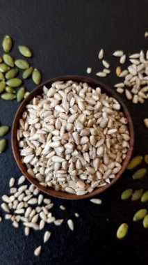 Kabuklu ay çekirdeği çekirdekleri, tuzlanmış, kavrulmuş ya da çiğ, sağlıklı bir bileşendir. Tasarımınız için gıda arka planı olarak ayçiçeği tohumları