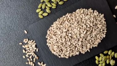 Kabuklu ay çekirdeği çekirdekleri, tuzlanmış, kavrulmuş ya da çiğ, sağlıklı bir bileşendir. Tasarımınız için gıda arka planı olarak ayçiçeği tohumları