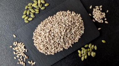 Kabuklu ay çekirdeği çekirdekleri, tuzlanmış, kavrulmuş ya da çiğ, sağlıklı bir bileşendir. Tasarımınız için gıda arka planı olarak ayçiçeği tohumları