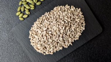 Kabuklu ay çekirdeği çekirdekleri, tuzlanmış, kavrulmuş ya da çiğ, sağlıklı bir bileşendir. Tasarımınız için gıda arka planı olarak ayçiçeği tohumları