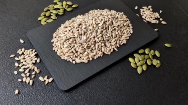 Kabuklu ay çekirdeği çekirdekleri, tuzlanmış, kavrulmuş ya da çiğ, sağlıklı bir bileşendir. Tasarımınız için gıda arka planı olarak ayçiçeği tohumları