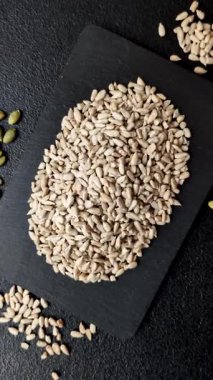 Kabuklu ay çekirdeği çekirdekleri, tuzlanmış, kavrulmuş ya da çiğ, sağlıklı bir bileşendir. Tasarımınız için gıda arka planı olarak ayçiçeği tohumları