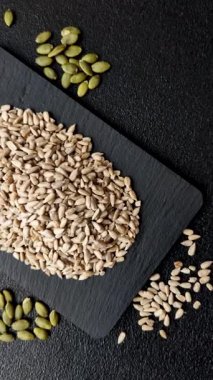 Kabuklu ay çekirdeği çekirdekleri, tuzlanmış, kavrulmuş ya da çiğ, sağlıklı bir bileşendir. Tasarımınız için gıda arka planı olarak ayçiçeği tohumları