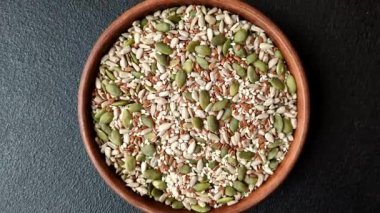 Sağlıklı yiyecekler için kabuklu ayçiçeği, susam, balkabağı ve keten tohumu çekirdekleri. Tasarımınız için gıda arka planı olarak tohumlar ve tahıllar.