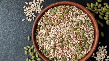 Sağlıklı yiyecekler için kabuklu ayçiçeği, susam, balkabağı ve keten tohumu çekirdekleri. Tasarımınız için gıda arka planı olarak tohumlar ve tahıllar.