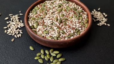 Sağlıklı yiyecekler için kabuklu ayçiçeği, susam, balkabağı ve keten tohumu çekirdekleri. Tasarımınız için gıda arka planı olarak tohumlar ve tahıllar.