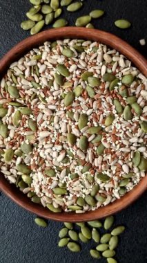 Sağlıklı yiyecekler için kabuklu ayçiçeği, susam, balkabağı ve keten tohumu çekirdekleri. Tasarımınız için gıda arka planı olarak tohumlar ve tahıllar.