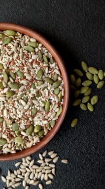 Sağlıklı yiyecekler için kabuklu ayçiçeği, susam, balkabağı ve keten tohumu çekirdekleri. Tasarımınız için gıda arka planı olarak tohumlar ve tahıllar.