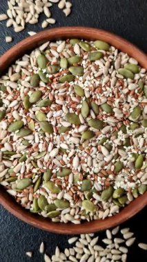 Sağlıklı yiyecekler için kabuklu ayçiçeği, susam, balkabağı ve keten tohumu çekirdekleri. Tasarımınız için gıda arka planı olarak tohumlar ve tahıllar.