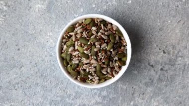 Sağlıklı yiyecekler için kabuklu ayçiçeği, susam, balkabağı ve keten tohumu çekirdekleri. Tasarımınız için gıda arka planı olarak tohumlar ve tahıllar.