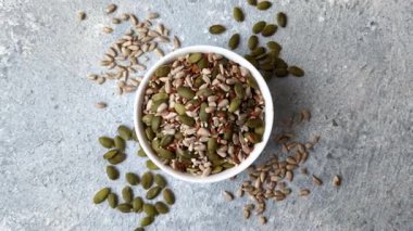 Sağlıklı yiyecekler için kabuklu ayçiçeği, susam, balkabağı ve keten tohumu çekirdekleri. Tasarımınız için gıda arka planı olarak tohumlar ve tahıllar.