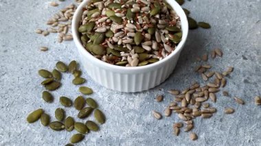 Sağlıklı yiyecekler için kabuklu ayçiçeği, susam, balkabağı ve keten tohumu çekirdekleri. Tasarımınız için gıda arka planı olarak tohumlar ve tahıllar.