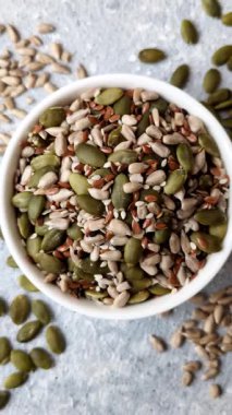 Sağlıklı yiyecekler için kabuklu ayçiçeği, susam, balkabağı ve keten tohumu çekirdekleri. Tasarımınız için gıda arka planı olarak tohumlar ve tahıllar.