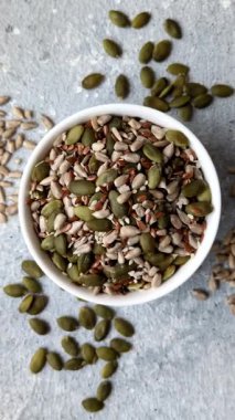 Sağlıklı yiyecekler için kabuklu ayçiçeği, susam, balkabağı ve keten tohumu çekirdekleri. Tasarımınız için gıda arka planı olarak tohumlar ve tahıllar.