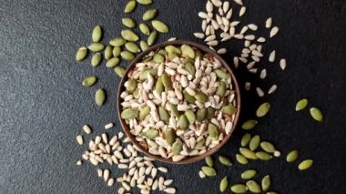 Sağlıklı yiyecekler için kabuklu ayçiçeği, susam, balkabağı ve keten tohumu çekirdekleri. Tasarımınız için gıda arka planı olarak tohumlar ve tahıllar.