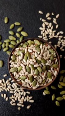 Sağlıklı yiyecekler için kabuklu ayçiçeği, susam, balkabağı ve keten tohumu çekirdekleri. Tasarımınız için gıda arka planı olarak tohumlar ve tahıllar.