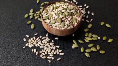 Sağlıklı yiyecekler için kabuklu ayçiçeği, susam, balkabağı ve keten tohumu çekirdekleri. Tasarımınız için gıda arka planı olarak tohumlar ve tahıllar.