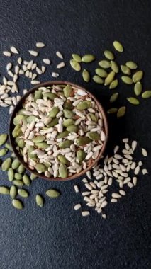 Sağlıklı yiyecekler için kabuklu ayçiçeği, susam, balkabağı ve keten tohumu çekirdekleri. Tasarımınız için gıda arka planı olarak tohumlar ve tahıllar.