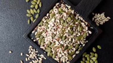 Sağlıklı yiyecekler için kabuklu ayçiçeği, susam, balkabağı ve keten tohumu çekirdekleri. Tasarımınız için gıda arka planı olarak tohumlar ve tahıllar.