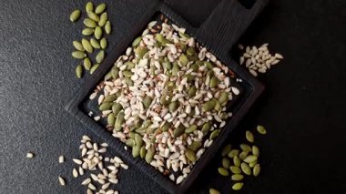 Sağlıklı yiyecekler için kabuklu ayçiçeği, susam, balkabağı ve keten tohumu çekirdekleri. Tasarımınız için gıda arka planı olarak tohumlar ve tahıllar.