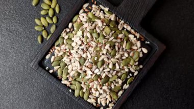 Sağlıklı yiyecekler için kabuklu ayçiçeği, susam, balkabağı ve keten tohumu çekirdekleri. Tasarımınız için gıda arka planı olarak tohumlar ve tahıllar.