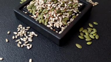 Sağlıklı yiyecekler için kabuklu ayçiçeği, susam, balkabağı ve keten tohumu çekirdekleri. Tasarımınız için gıda arka planı olarak tohumlar ve tahıllar.