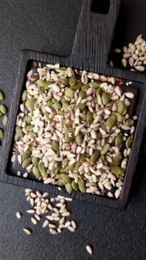 Sağlıklı yiyecekler için kabuklu ayçiçeği, susam, balkabağı ve keten tohumu çekirdekleri. Tasarımınız için gıda arka planı olarak tohumlar ve tahıllar.