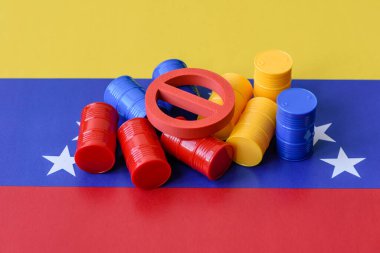 Venezuela bayrağında bulunan metal varil petrol, gaz veya kimyasallar ve Venezuela üretimine uygulanan yasaklama işareti. İran petrolünün varilleri