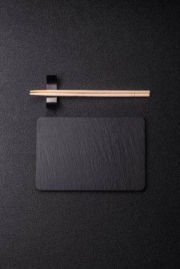 Mutfak tezgahında çatal bıçak takımı olan boş bir tahta. Slate kesme tahtası, tasarımın için gıda arka planı