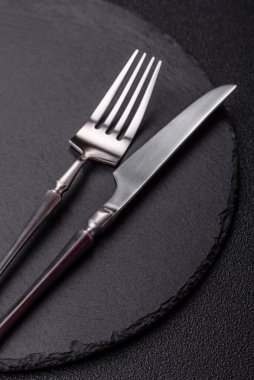 Mutfak tezgahında çatal bıçak takımı olan boş bir tahta. Slate kesme tahtası, tasarımın için gıda arka planı