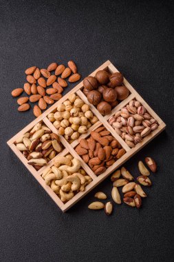 Sağlıklı gıda malzemesi olarak kaju, fıstık, badem, Brezilya fındığı, macadamia ve fındık karışımı. Tasarımınız için yemek arkaplanı olarak fındık