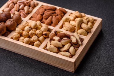 Sağlıklı gıda malzemesi olarak kaju, fıstık, badem, Brezilya fındığı, macadamia ve fındık karışımı. Tasarımınız için yemek arkaplanı olarak fındık