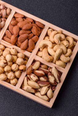 Sağlıklı gıda malzemesi olarak kaju, fıstık, badem, Brezilya fındığı, macadamia ve fındık karışımı. Tasarımınız için yemek arkaplanı olarak fındık