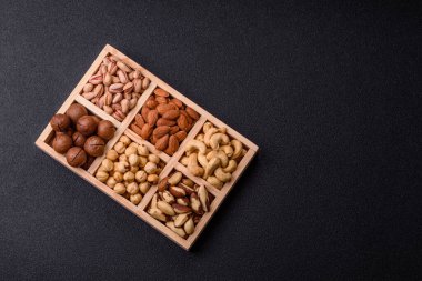 Sağlıklı gıda malzemesi olarak kaju, fıstık, badem, Brezilya fındığı, macadamia ve fındık karışımı. Tasarımınız için yemek arkaplanı olarak fındık