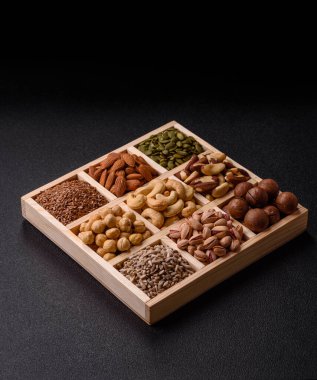 Sağlıklı gıda malzemesi olarak kaju, fıstık, badem, Brezilya fındığı, macadamia ve fındık karışımı. Tasarımınız için yemek arkaplanı olarak fındık