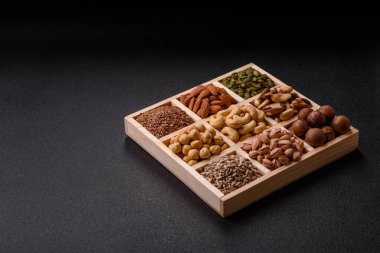 Sağlıklı gıda malzemesi olarak kaju, fıstık, badem, Brezilya fındığı, macadamia ve fındık karışımı. Tasarımınız için yemek arkaplanı olarak fındık