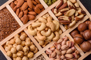 Sağlıklı gıda malzemesi olarak kaju, fıstık, badem, Brezilya fındığı, macadamia ve fındık karışımı. Tasarımınız için yemek arkaplanı olarak fındık