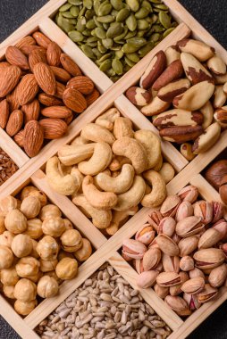 Sağlıklı gıda malzemesi olarak kaju, fıstık, badem, Brezilya fındığı, macadamia ve fındık karışımı. Tasarımınız için yemek arkaplanı olarak fındık