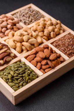 Sağlıklı gıda malzemesi olarak kaju, fıstık, badem, Brezilya fındığı, macadamia ve fındık karışımı. Tasarımınız için yemek arkaplanı olarak fındık