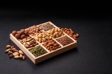 Sağlıklı gıda malzemesi olarak kaju, fıstık, badem, Brezilya fındığı, macadamia ve fındık karışımı. Tasarımınız için yemek arkaplanı olarak fındık