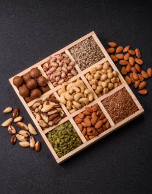 Sağlıklı gıda malzemesi olarak kaju, fıstık, badem, Brezilya fındığı, macadamia ve fındık karışımı. Tasarımınız için yemek arkaplanı olarak fındık