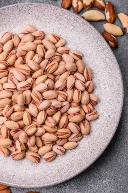 Sağlıklı, yüksek kalorili bir gıda malzemesi olarak kabuklu şam fıstığı. Tasarımınız için yemek arkaplanı olarak fıstıklar
