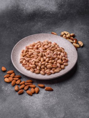 Sağlıklı, yüksek kalorili bir gıda malzemesi olarak kabuklu şam fıstığı. Tasarımınız için yemek arkaplanı olarak fıstıklar