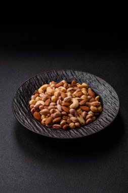 Sağlıklı gıda malzemesi olarak kaju, fıstık, badem, Brezilya fındığı, macadamia ve fındık karışımı. Tasarımınız için yemek arkaplanı olarak fındık