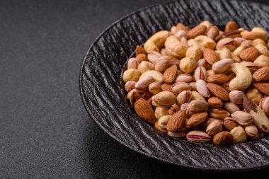 Sağlıklı gıda malzemesi olarak kaju, fıstık, badem, Brezilya fındığı, macadamia ve fındık karışımı. Tasarımınız için yemek arkaplanı olarak fındık