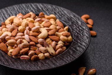 Sağlıklı gıda malzemesi olarak kaju, fıstık, badem, Brezilya fındığı, macadamia ve fındık karışımı. Tasarımınız için yemek arkaplanı olarak fındık