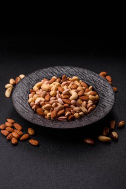 Sağlıklı gıda malzemesi olarak kaju, fıstık, badem, Brezilya fındığı, macadamia ve fındık karışımı. Tasarımınız için yemek arkaplanı olarak fındık